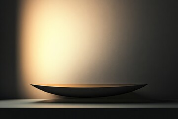 Fototapete - A curved dish sits gracefully under a focused warm spotlight, creating a contrast between the light-drenched surface and the dimly lit surroundings.