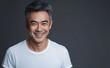 © Jiraphat - A smiling man with gray hair wears a plain white t-shirt against a dark background, exuding confidence and warmth.