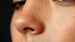 © JAKE STUDIO - Close-up of a person's nose displaying textured skin and pores, highlighting natural beauty and skin details against a dark background.