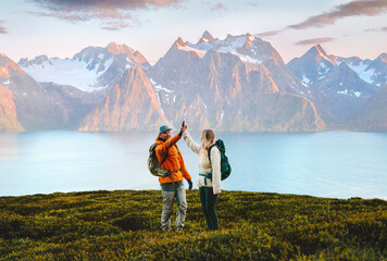 Wall Mural - couple friends high five hands on mountain top man and woman backpackers travel together hiking in n