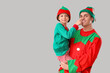 © Pixel-Shot - Father and his cute little son in elf's costumes on grey background