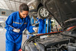 © kelvn - Female Auto mechanic are checking and repair maintenance auto engine is problems at car repair shop.