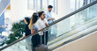 © peopleimages.com - Business people, escalator and travel at airport with suitcase for flight, international journey and brokers chat. Team trip, workers and luggage at lobby for arrival, immigration and women talking