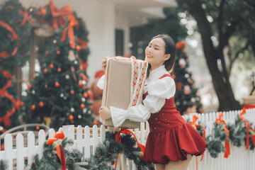 Christmas Cheer: A young woman embraces a large gift, radiating festive joy amidst a charming Christmas setting.  The image captures the spirit of the season. 