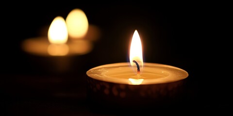 Aufkleber - Candle light illuminates a dark background, creating a warm and serene atmosphere. The soft glow of candle light enhances the mood and adds a touch of elegance to any setting.