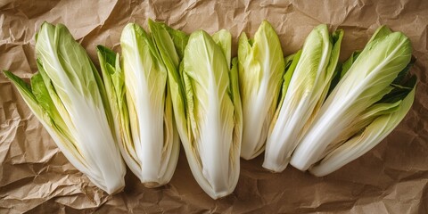 Poster - Fresh green endive displayed on crumpled brown craft paper from a top view perspective, highlighting the vibrant colors and textures of the endive. Ideal for culinary and food related themes.