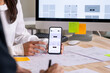 © amenic181 - UX UI designer testing prototype on a phone, discussing and brainstorming on wireframes for a website and mobile app prototype, in the concept of website and mobile application design concept.