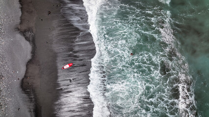 Surfer navigating the waves on a beach in Taiwan during a sunny day near the shoreline