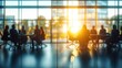 © Viktor - Business people meeting in modern office. Sunlight streams through large windows. Silhouettes of people engaged in discussion around a table. Indoor meeting space. Pro business environment.