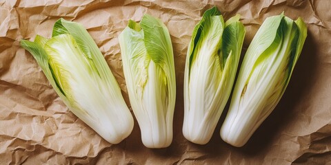 Poster - Fresh green endive displayed on crumpled brown craft paper from a top view perspective, highlighting the vibrant colors and textures of the endive. Ideal for culinary and food related themes.