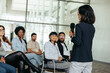 © Jacob Lund - Asian business woman speaker giving a presentation at a conference with an engaged audience