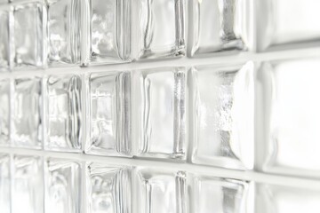 Poster - A detailed view of clear glass blocks arranged in a wall, glinting with natural light, creating an elegant and modern architectural element with transparency and texture.