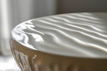 Leinwandbilder - A minimalist abstract design characterized by soft, wavy patterns on a glossy white tabletop surface, reflecting light and shadows to create a serene visual experience.