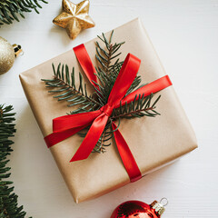 Top view of a Christmas gift box wrapped in brown craft paper with a red ribbon, isolated on a clean white background, perfect for holiday, gift-giving, and festive celebration themes.