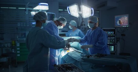 Poster - Dark Operating Room with a Diverse Team Performing a Precise Surgical Procedure as Teamwork and Under Surgical Light. Female Surgeon Using Laparoscopy Instruments and Forceps for the Operation