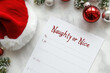 © Klay - naughty or nice list with santa hat and christmas decorations on a dark background, holiday planning concept