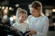 © c80 - A joyful mother and daughter embrace while examining a car, reflecting their strong bond. Both wear white sweaters, indicating unity and care.