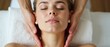 © schiers_images - A serene woman lies peacefully while receiving a soothing facial massage, embodying tranquility and relaxation in a spa setting, perfect for promoting wellness and self-care practices.