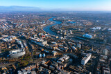 A stunning aerial view of Newcastle upon Tyne with the River Tyne, Millennium Bridge, and Sage Gateshead under a clear blue sky, showcasing the city's dynamic blend of history and modernity