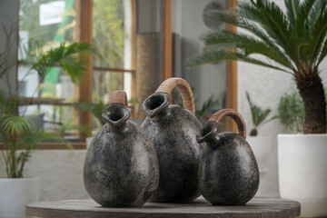 Three black ceramic vases with rattan handles make a stylish statement.