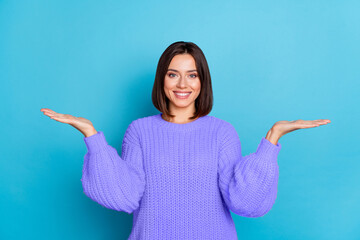 Wall Mural - Portrait of attractive cheerful brown-haired girl holding on palms copy space ad isolated over bright blue color background