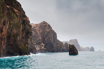 Wall Mural - Vestmannaeyjar island is under gray dramatic sky, seaside view