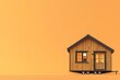 © Anton - Tiny house on wheels against orange backdrop, minimalist concept