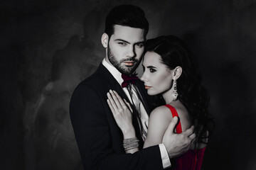 Poster - Portrait of lovely romantic couple embracing, pretty charming mrs with bijoutery, rich virile mr with bristle in tuxedo with bow isolated on grey background