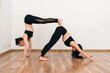 © Bohdan - Two slim girls are doing yoga