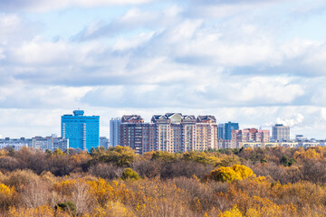 Wall Mural - blue cloudy sky over colorful city park and houses