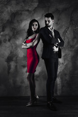 Poster - Full size fullbody vertical portrait of attractive confident couple with crossed arms looking at each other, charming slim lady in purple tight dress gentlemen in tuxedo isolated on grey wall