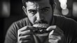 © Felippe Lopes - Young man savoring a burger in a dramatic black and white setting.