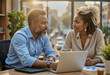 © f_bossa - A business photo in a modern office space: A man and woman sitting at a table looking at a laptop.