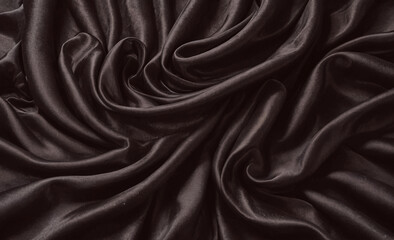 Aufkleber - Piece of black fabric with a pattern. The fabric is rolled up and has a shiny appearance