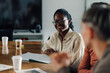 © Zamrznuti tonovi - Young african american businesswoman smiling during a meeting in the office