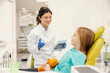 © Dusan Petkovic - Smiling dentist with panoramic x-ray in hands having consultations with a little girl at dentist office.