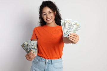 Poster - Happy woman with dollar banknotes on light grey background