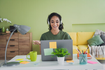 Wall Mural - Photo of attractive young woman call center operator dressed green outfit cozy day light home office interior living room