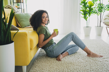 Wall Mural - Full length profile portrait of nice young girl sit floor hold coffee cup living room flat indoors