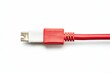 © Murda - Red cable with white connector, isolated background.