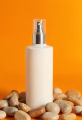 Wall Mural - Cosmetic Bottle with Silver Nozzle and Orange Background