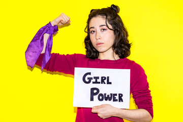 latina woman showing strength with girl power sign against yellow background