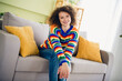 © deagreez - Portrait of pretty young woman sit comfy sofa wear sweater modern interior flat indoors