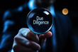 © Phichitpon - Due diligence concept, Businessman holding a magnifying glass with due diligence icon on virtual screen.