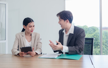 Wall Mural - Business team woman and man asian group meeting sitting on desk looking talk think creative idea computer on table ready happy working new project job online product sale marketing in office company.