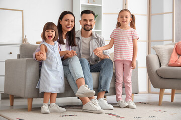 Canvas Print - Beautiful happy family sitting on sofa at home