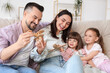 © Pixel-Shot - Happy family playing with wooden airplanes on sofa at home