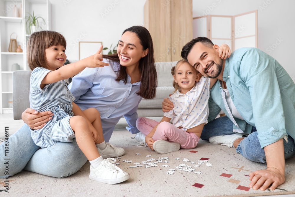 Happy family having fun together while doing puzzle on floor at home