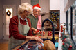 © Drazen - Senior couple washing dishes after baking Christmas cookies in the kitchen.