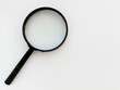 © Ira - A black magnifying glass on a white background. An empty space for the text. Research work. Scientific research. Background.